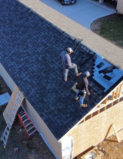 Construction Crew Finishing a roofing job.